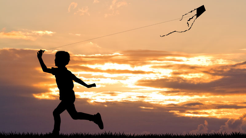 Innocent child flying kite enjoying life.